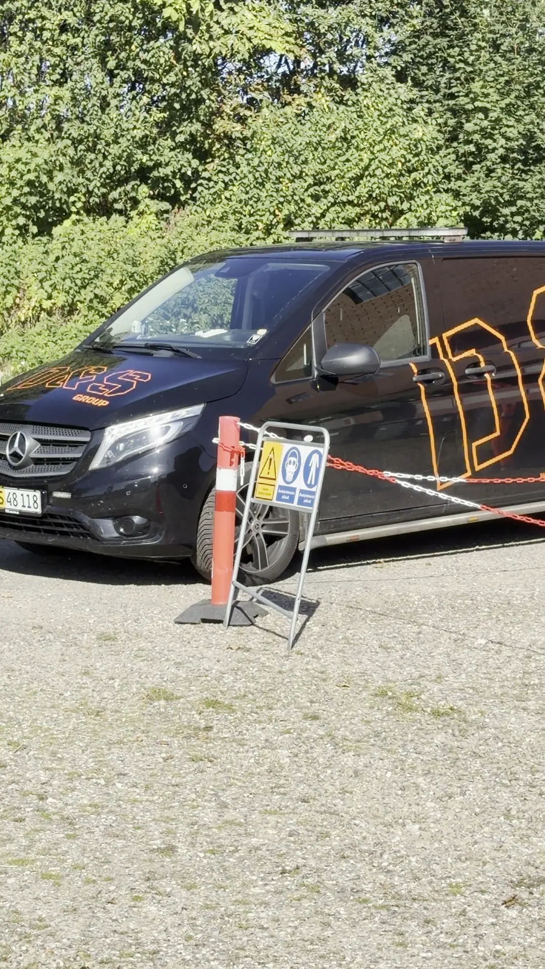 D&S Groups varevogn bag afspærring med påbudsskilte om åndedrætsværn og dragt